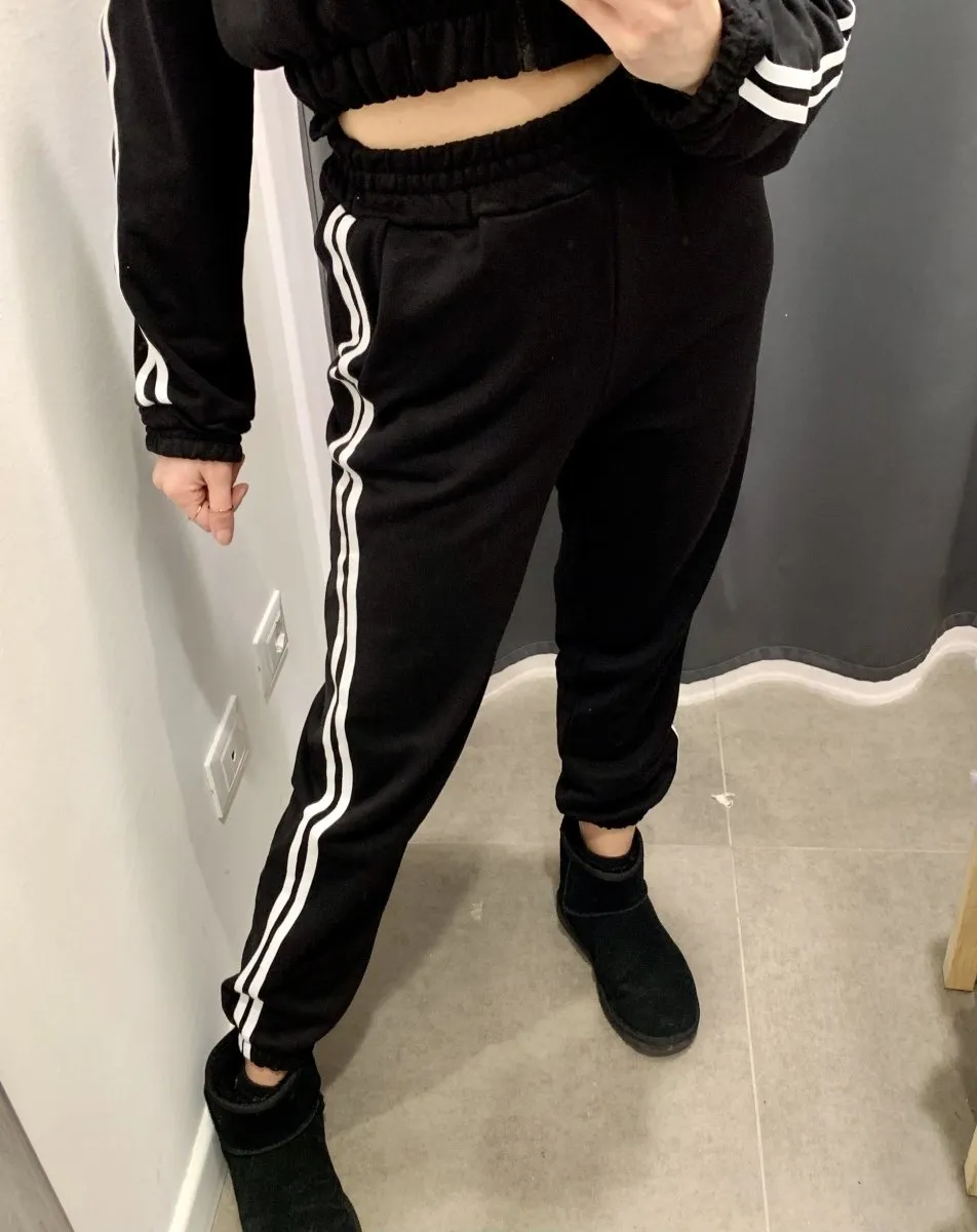 Black joggers with white side stripes.