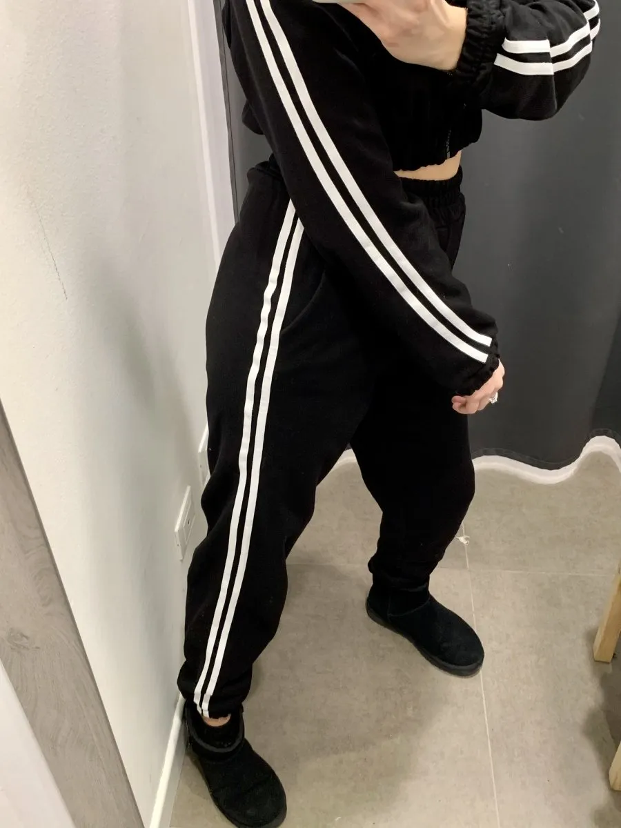 Black joggers with white side stripes.